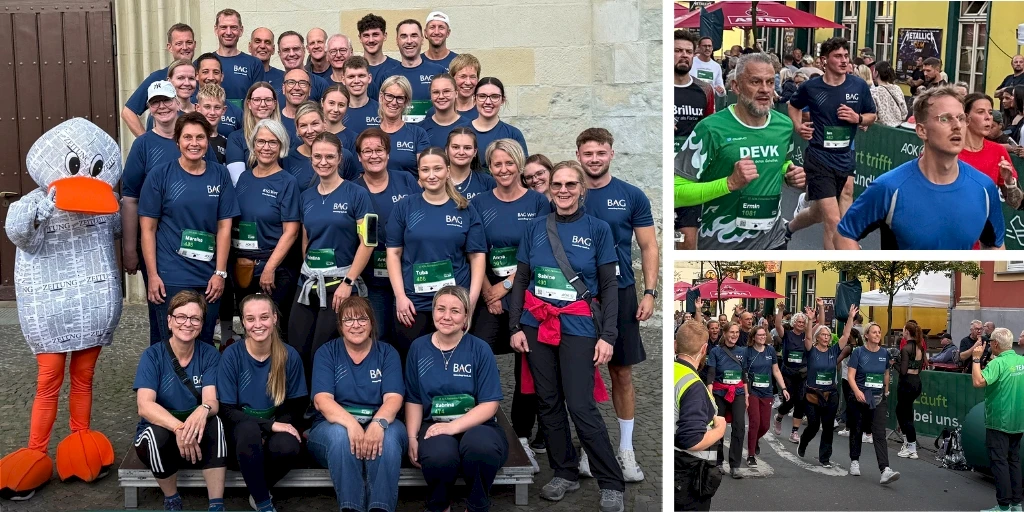 Gruppenfoto von Menschen in blauen T-Shirts mit grünen Startnummern neben einer Person im Entenkostüm vor einer Steinwand